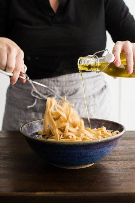 Tossing homemade pasta with olive oil