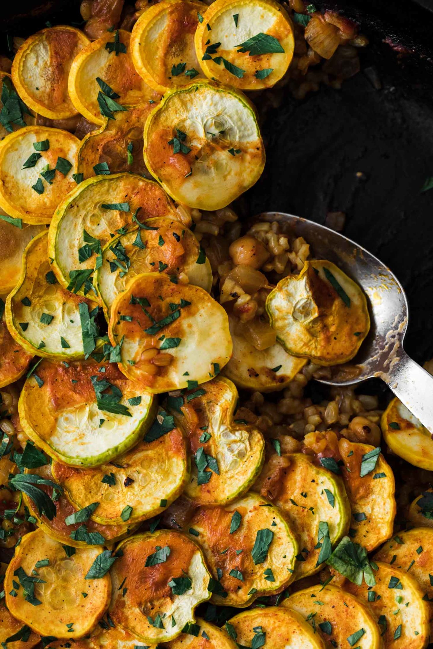 Close-up, overhead shot of vegetarian paella layered with summer squash.