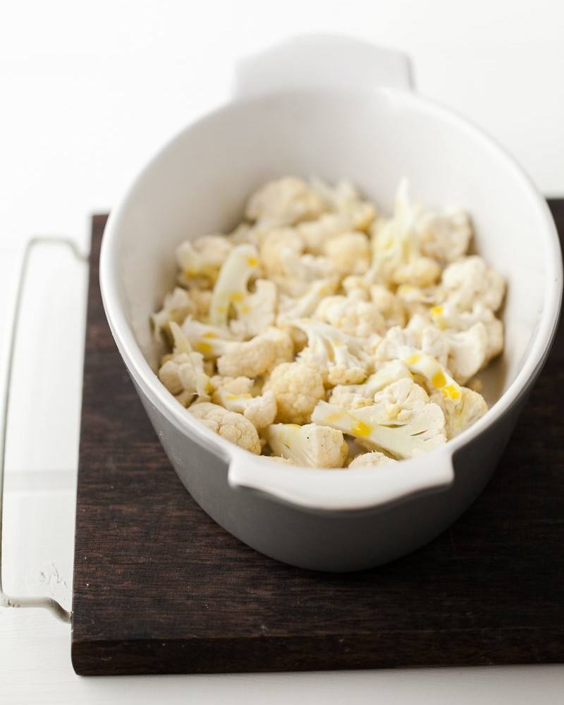 Side-angle shot of cauliflower florets with a drizzle of olive oil | Roasted Cauliflower Recipes.