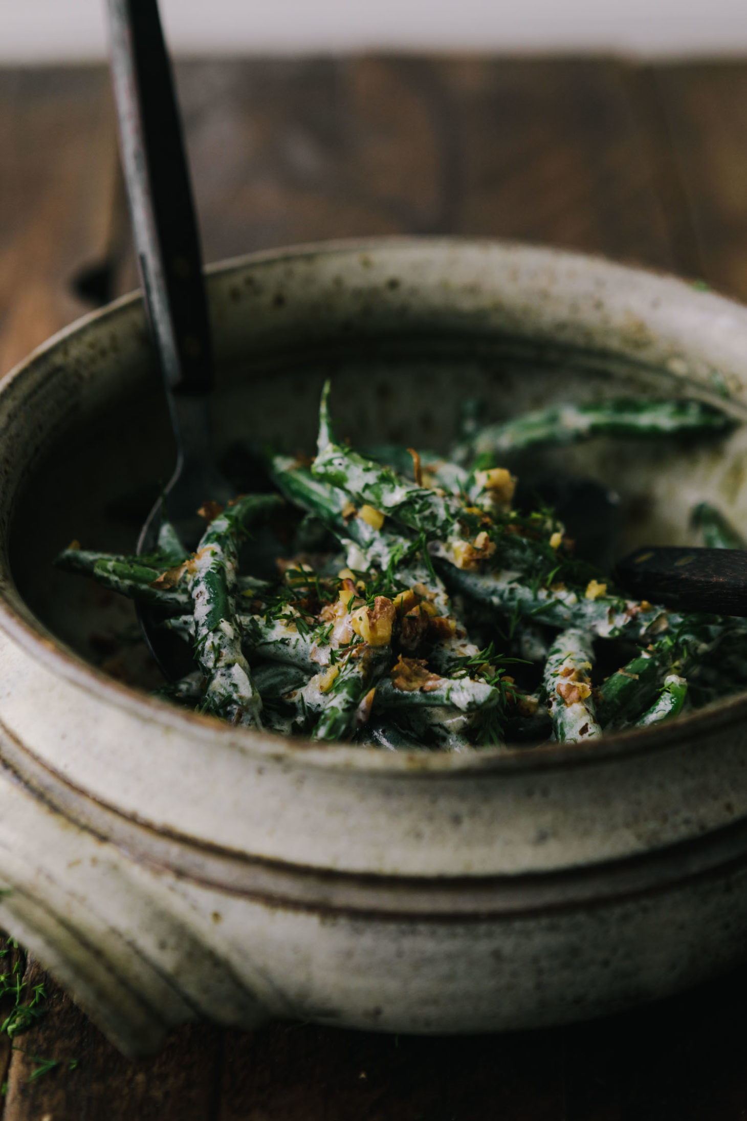 Side Angle Photo of green beans that have been blanched and tossed with walnuts and yogurt sauce.