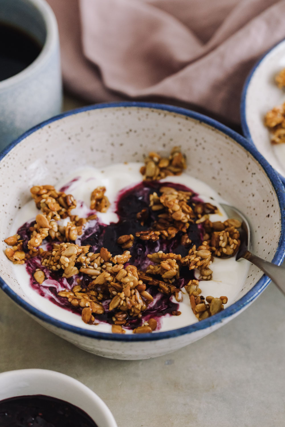 Close-up side angle of yogurt topped with blueberry chia jam and granola
