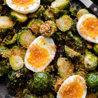 Close-up overhead shot of roasted Brussels sprouts and soft-boiled eggs
