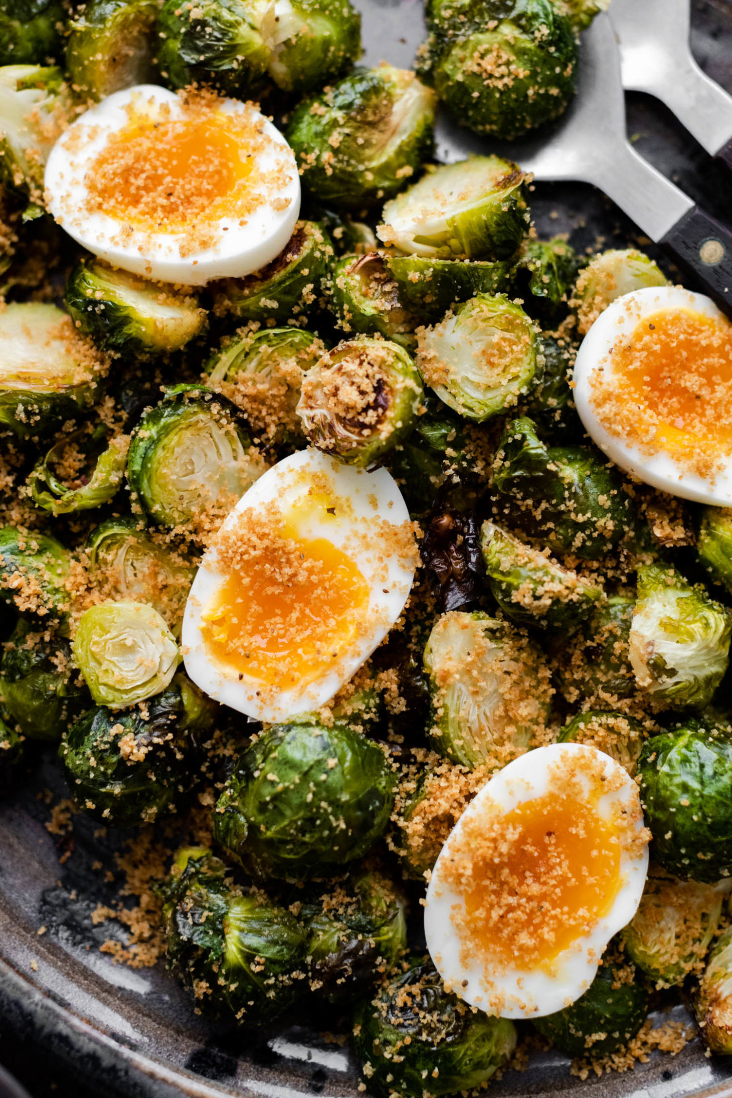 Close-up overhead shot of roasted Brussels sprouts and soft-boiled eggs