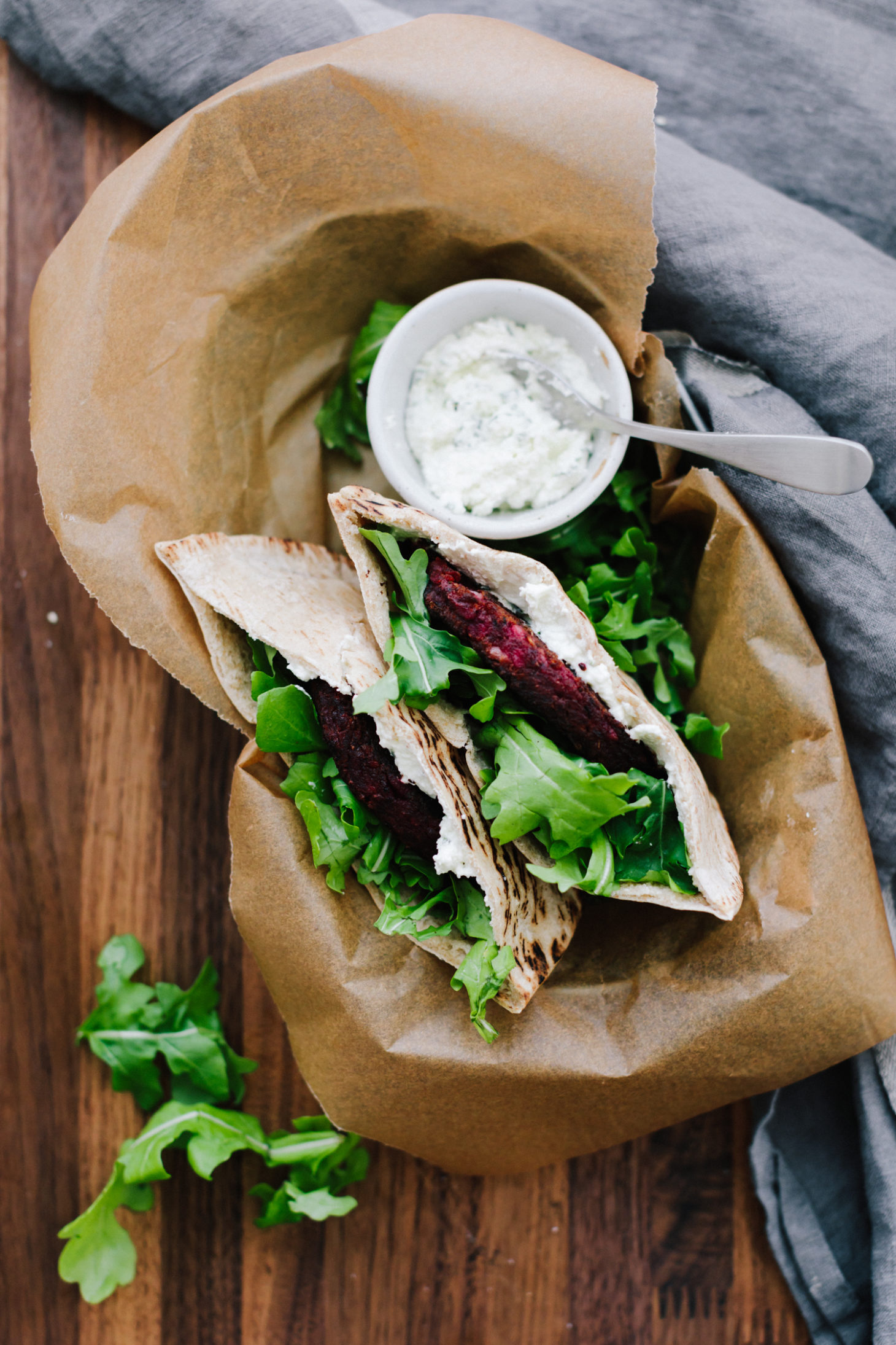 Overhead shot of pita stuffed with beet burgers, arugula, and whipped feta