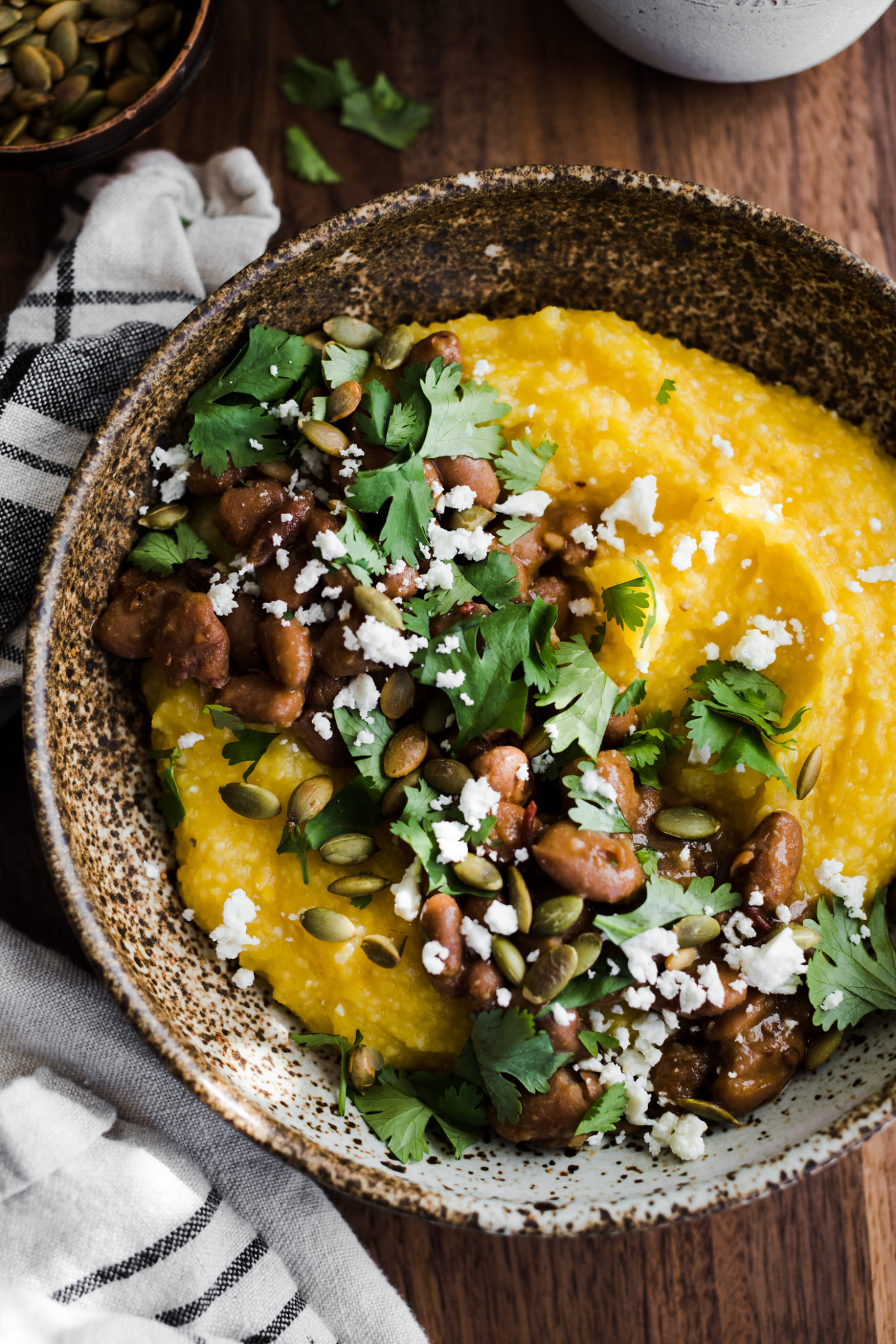 Close-up overhead photo of pumpkin polenta topped with chipotle pinto beans and cilantro