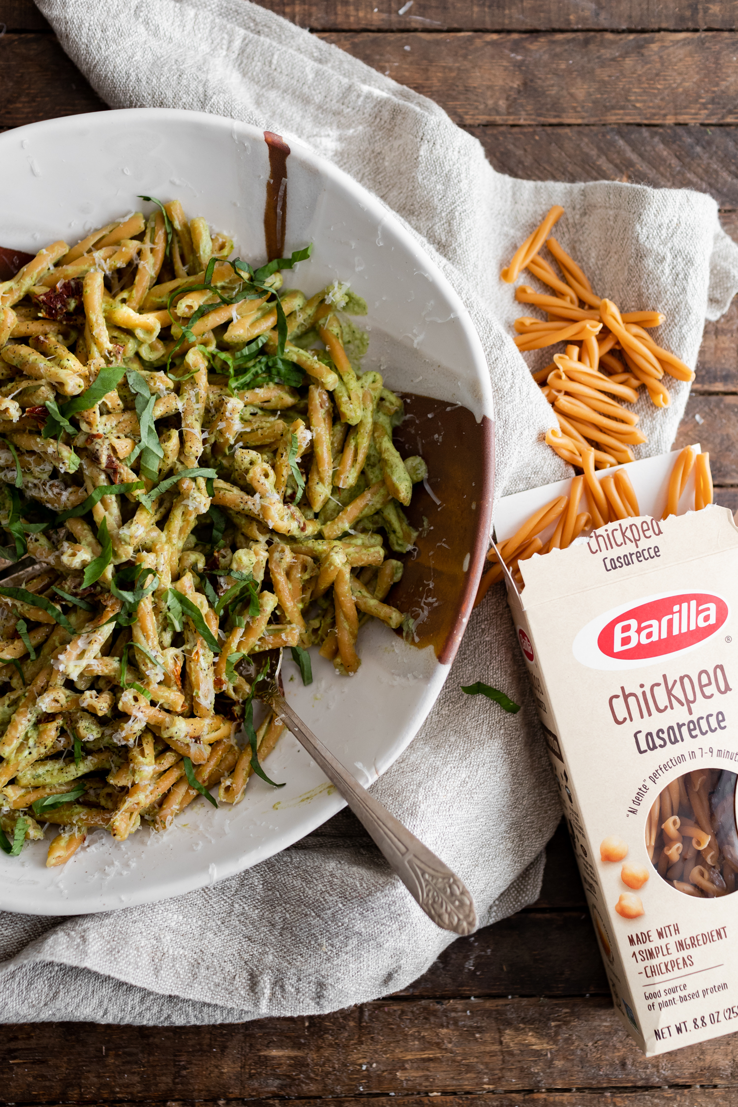 Overhead photo of a box of chickpea pasta next to a bowl of pasta with broccoli pesto.