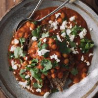 Overhead shot of chickpeas in a rich tomato sauce, all on a piece of toast.