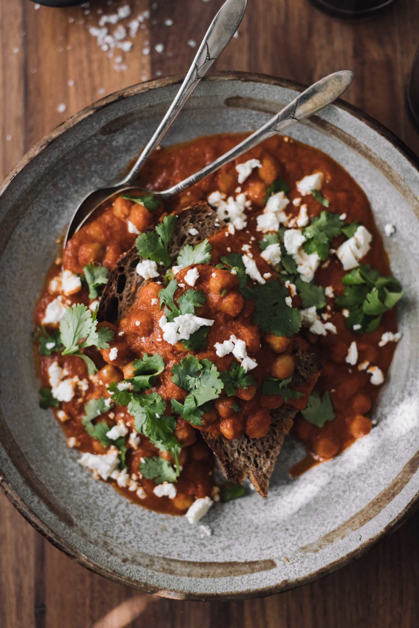 Overhead shot of chickpeas in a rich tomato sauce, all on a piece of toast.