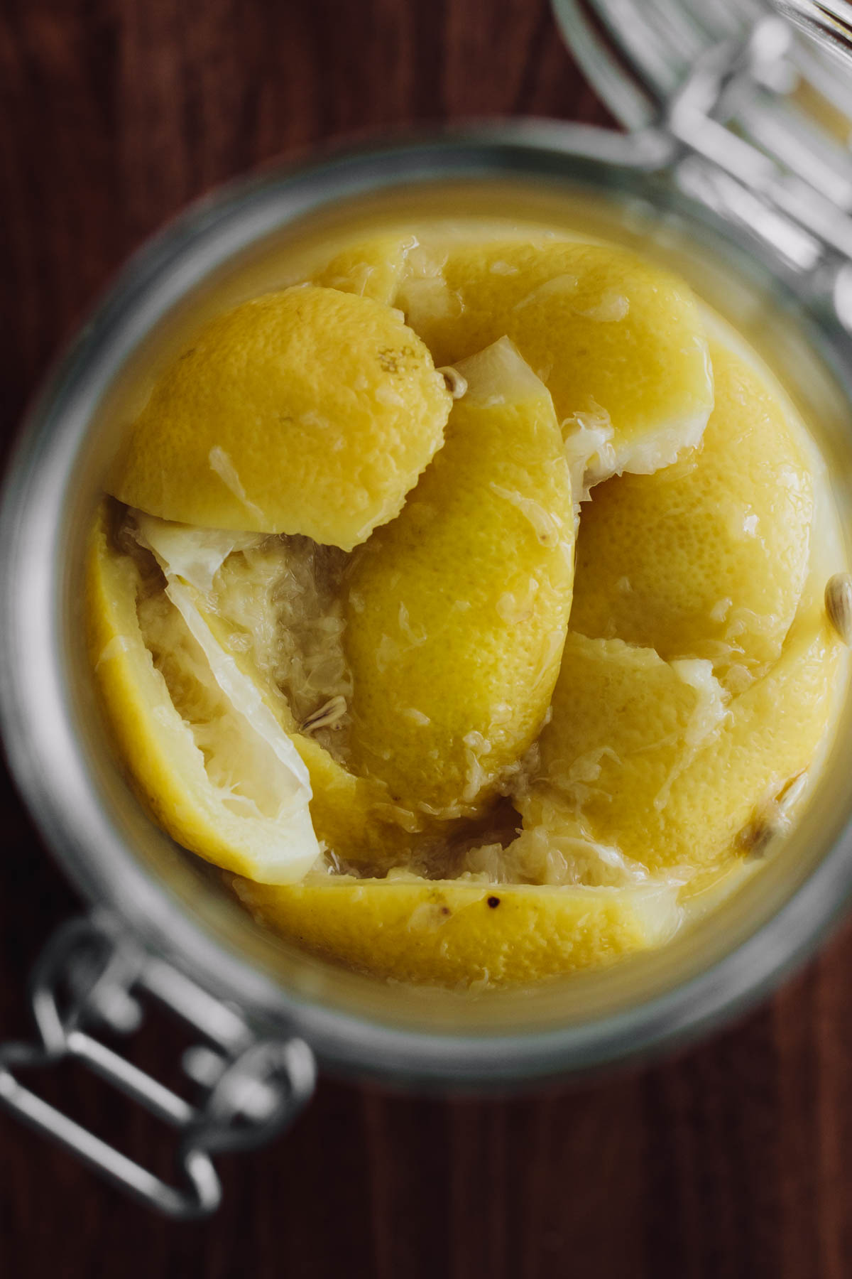 Close-up overhead photograph of lemons preserved in lemon juice and salt.