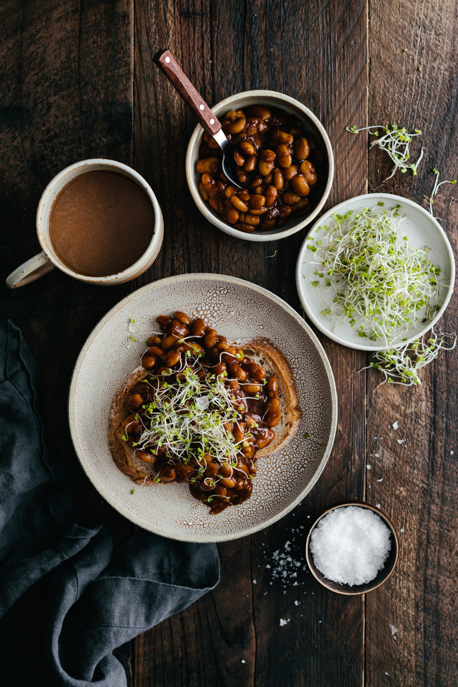 Overhead photo of a piece of toast topped with vegan baked beans and broccoli microgreens.