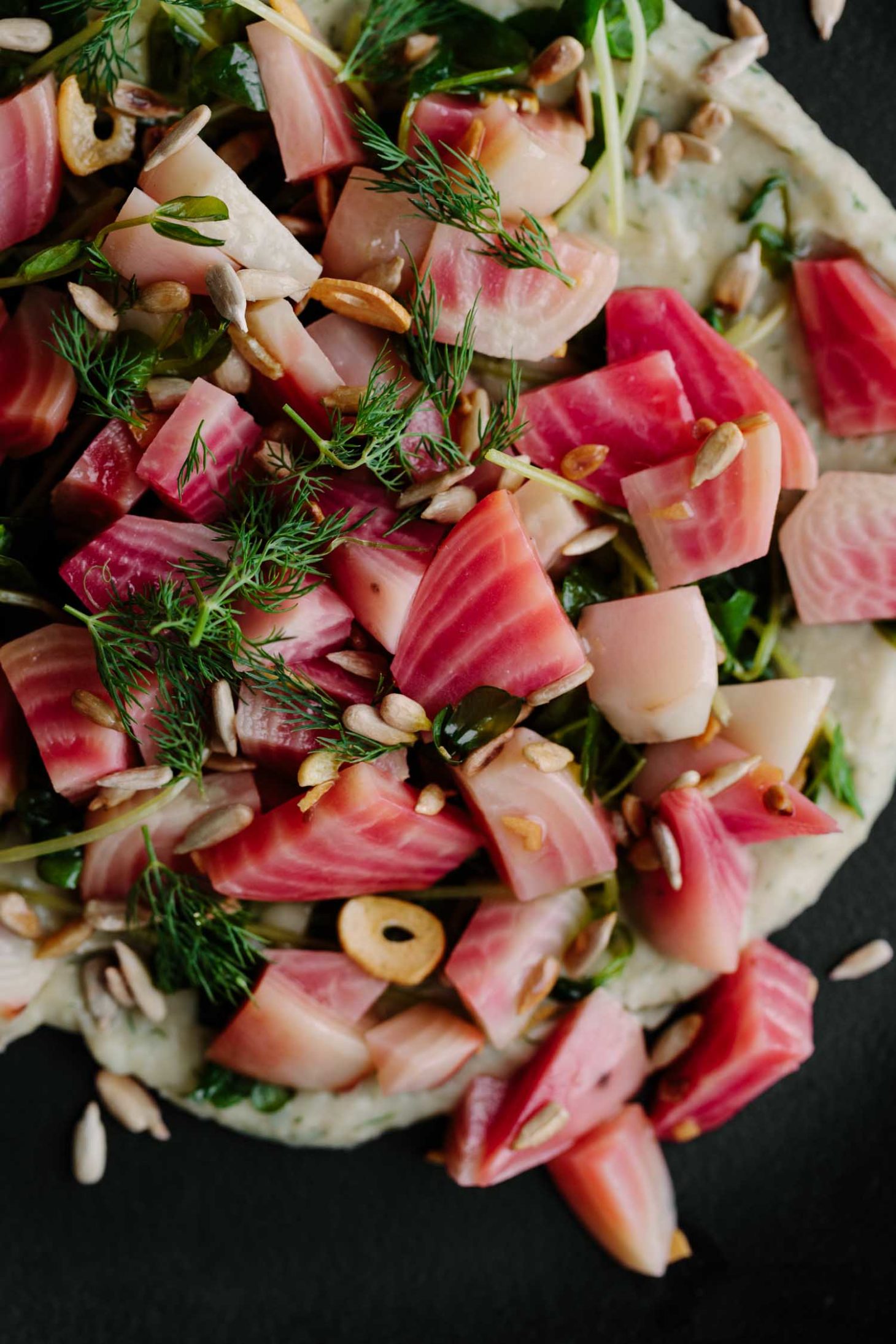 Close-up photograph of steamed beets with dill and bean puree.