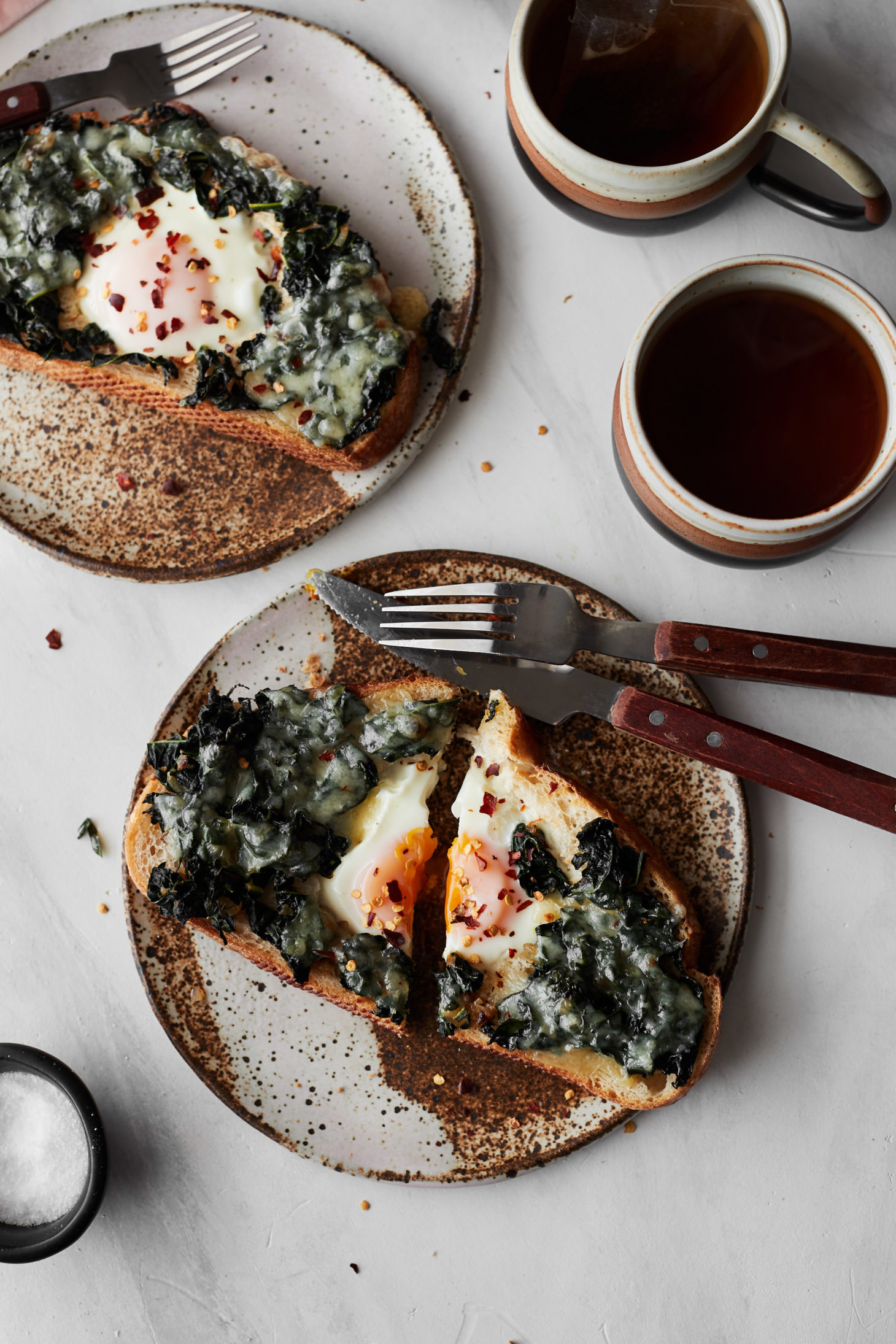 Overhead photo of Classic Egg in a Hole with sautéed kale and melty cheese, like havarti or taleggio. 