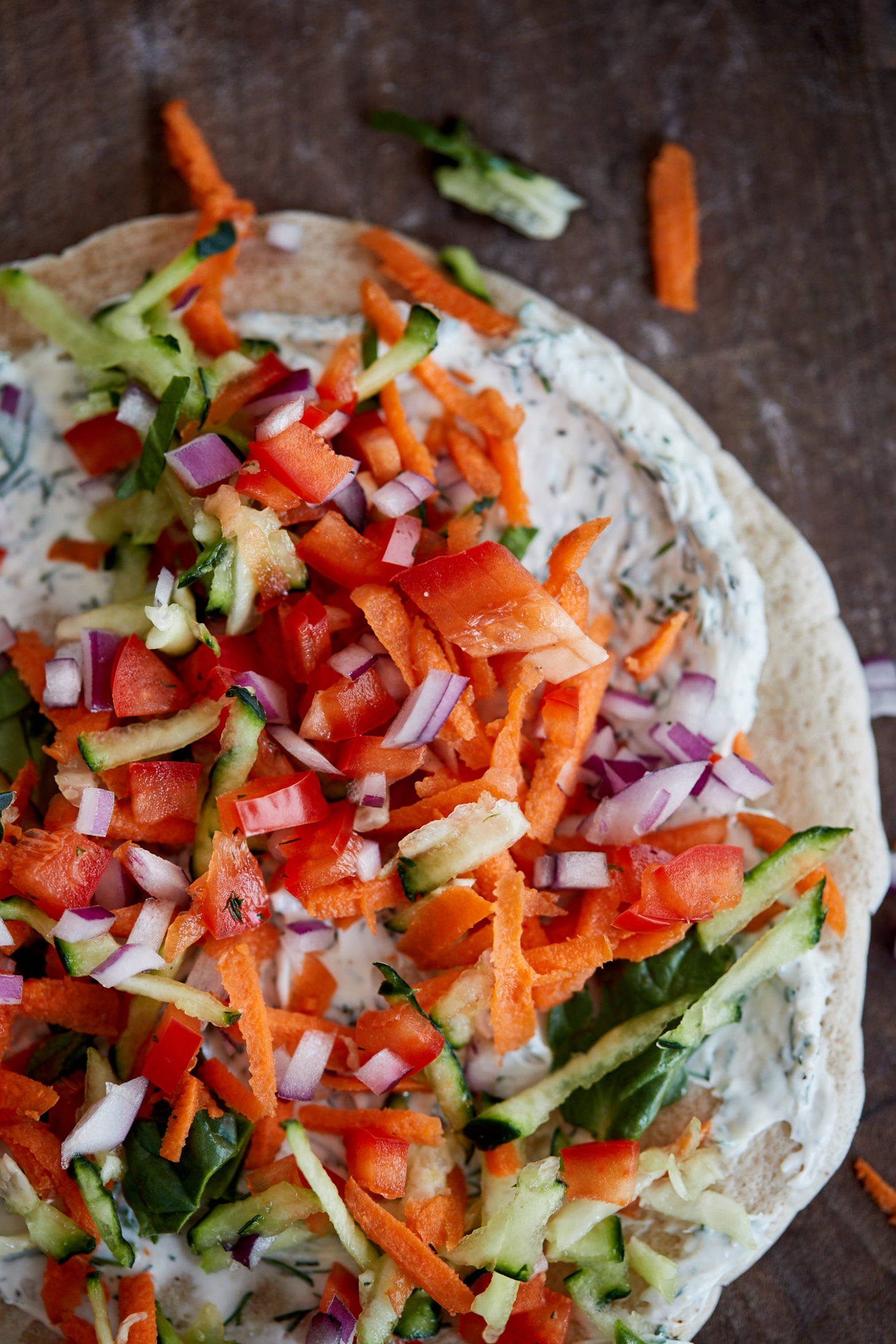 Overhead photograph of shredded vegetables, herbed cream cheese, and a whole wheat crepe