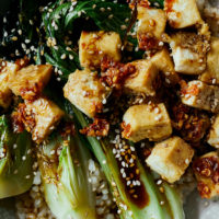close-up photography of crispy tofu on top of seared bok choy halves and rice