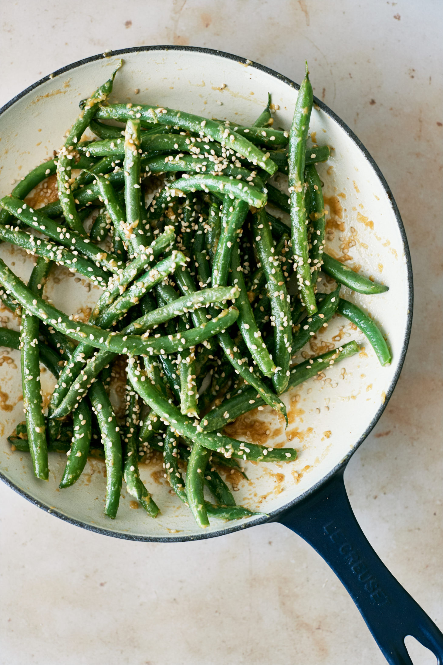 Overhead photo of green beans in a white enamel pan.