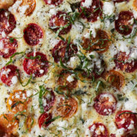 Close-up photograph of a frittata with cherry tomatoes, bulgur, and feta.