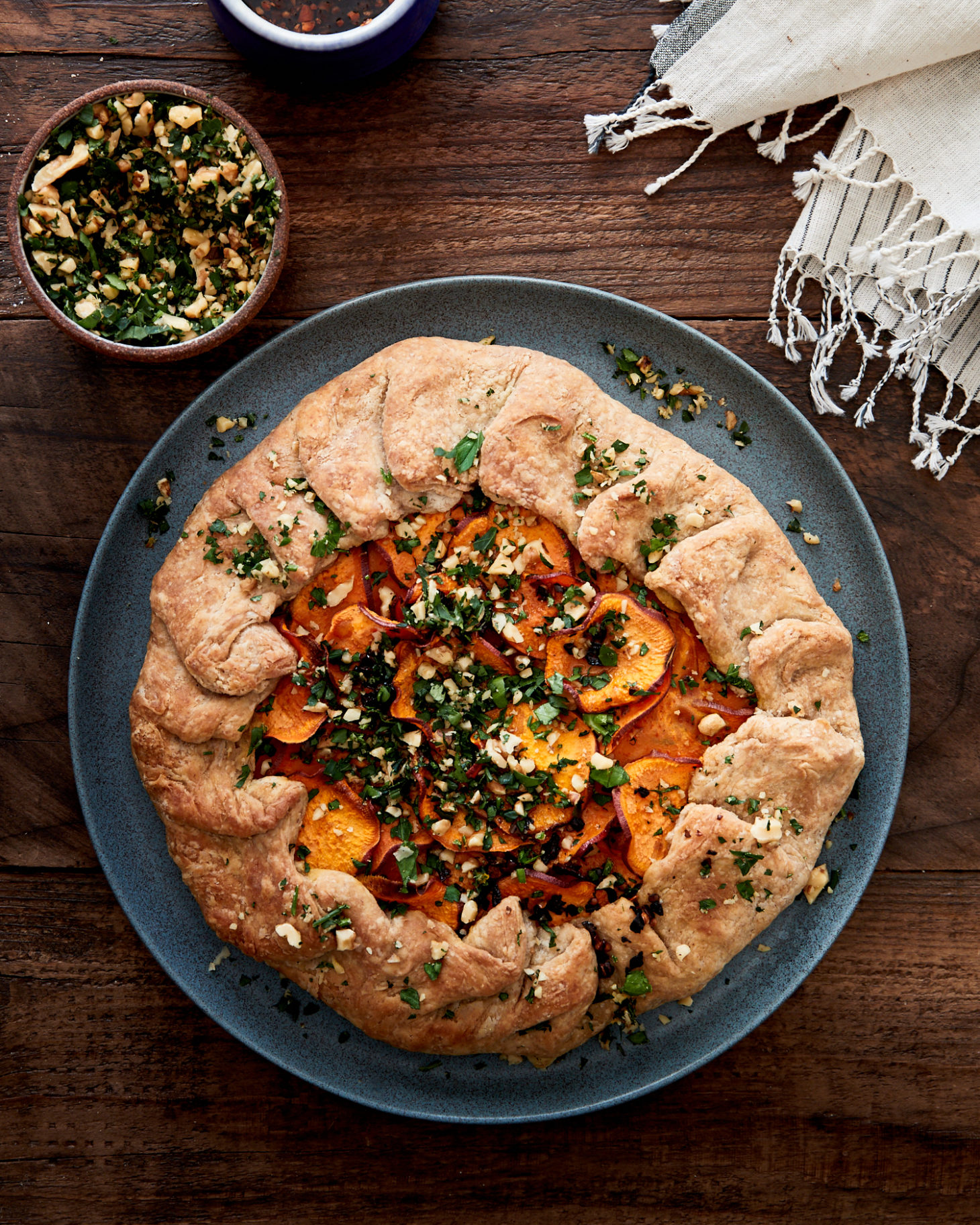 Close-up image of a whole wheat galette with sweet potatoes on a blue plate.