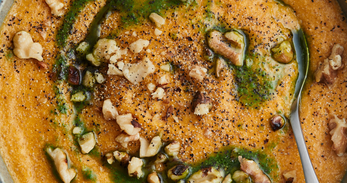 Close-up image of amaranth polenta with carrot puree and topped with parsley oil and walnuts.