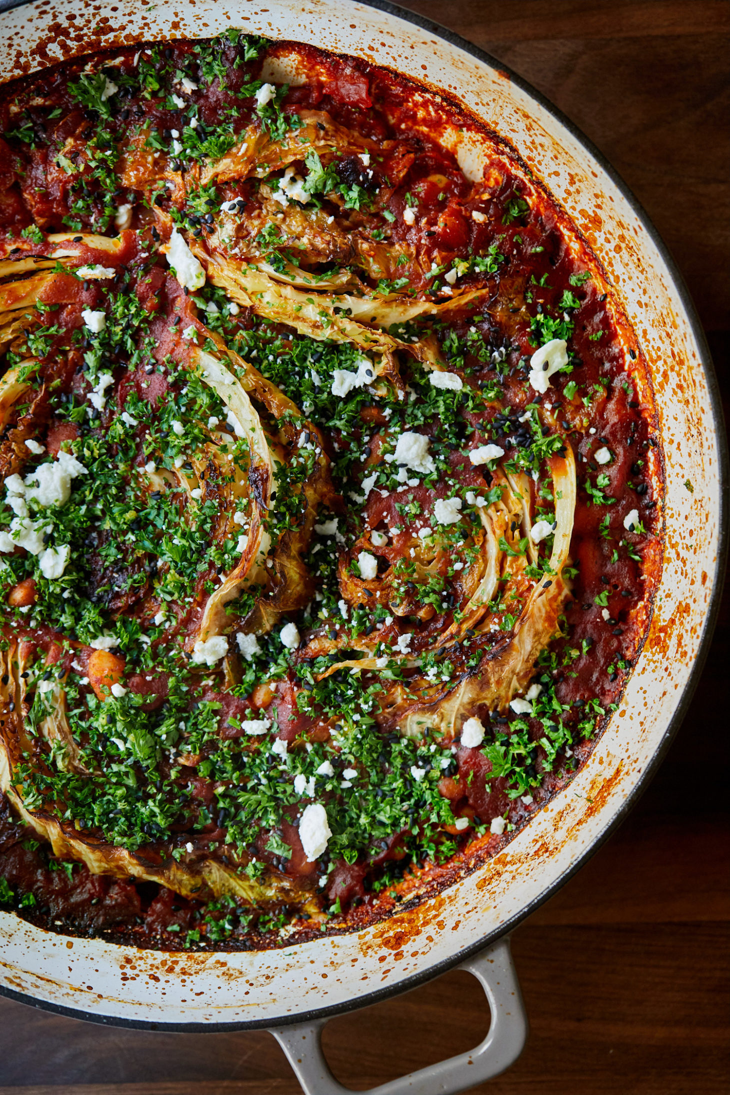 Close-up of cabbage wedges cooked in tomato sauce with white beans.