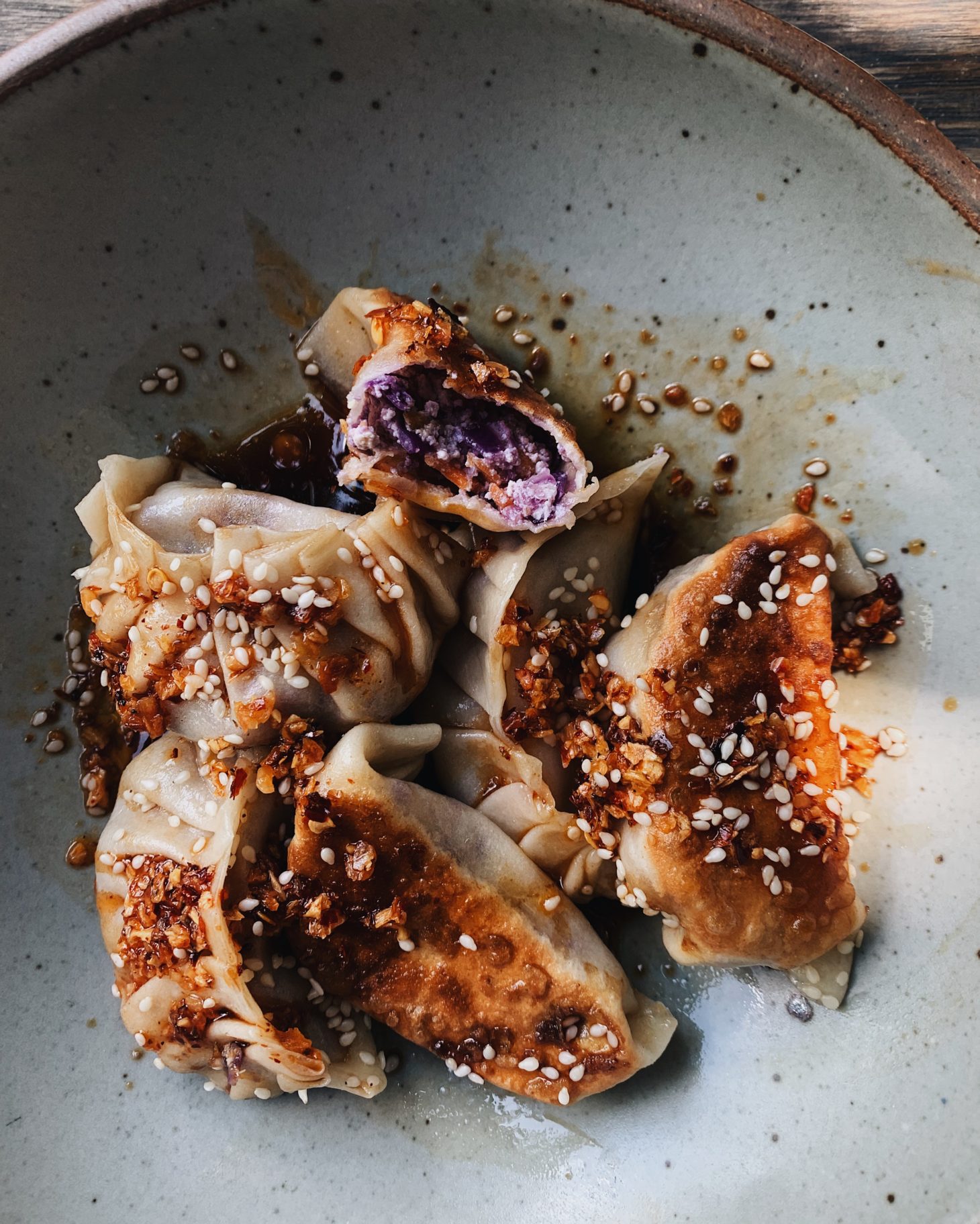 Close-up photo of potstickers with one open to reveal purple filling.