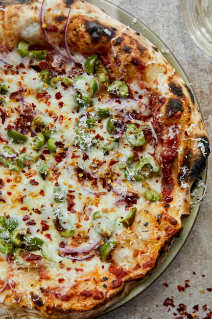 Close-up pizza with casteveltrano olives and red onions.