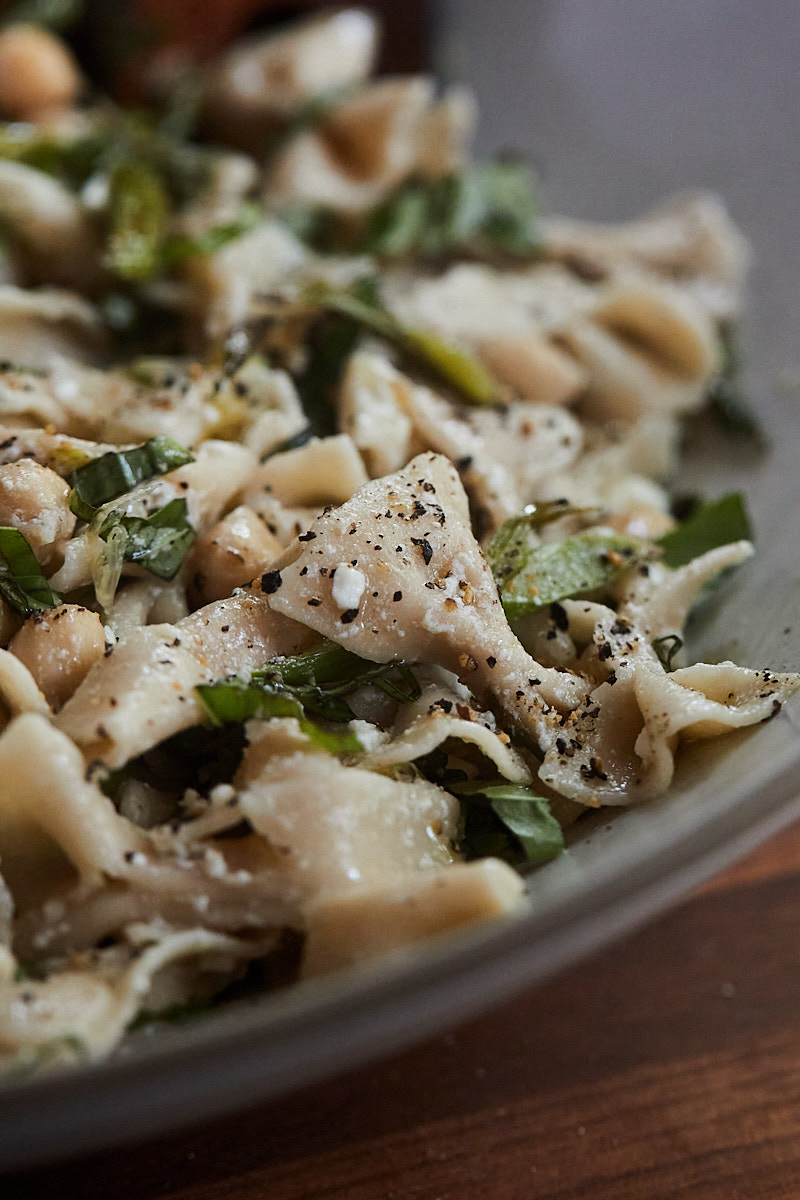 Close-up side photo of a asparagus pasta salad with chickpeas and farfalle pasta