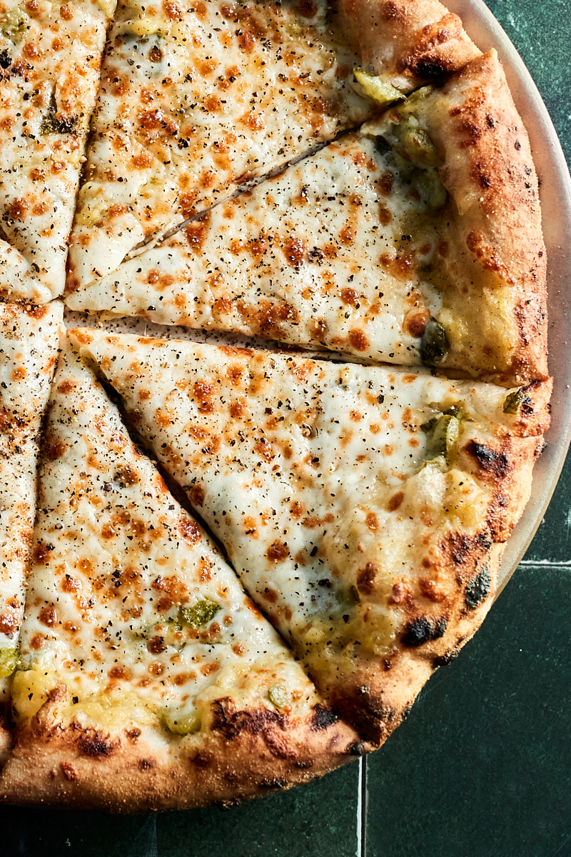 Close-up of three slices of a pizza with zucchini sauce and cheese