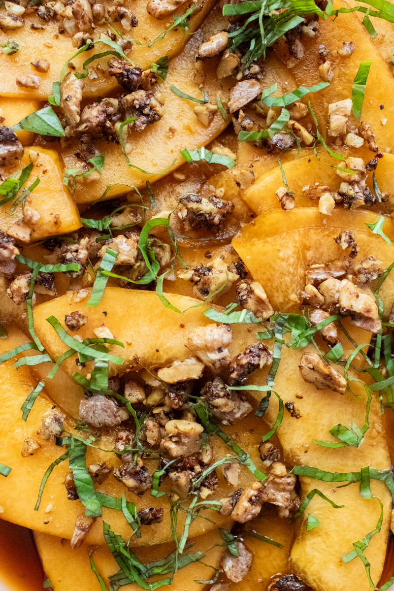 close-up image of marinated melon with basil and black pepper walnuts.