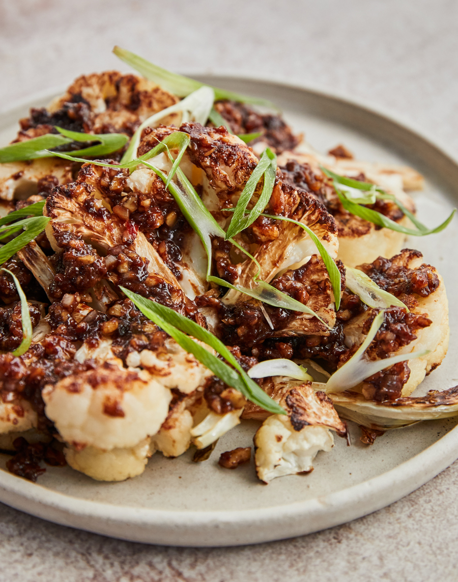 A close-up image of chile-walnut cauliflower with fresh scallions